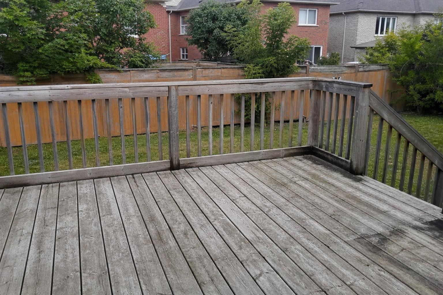 Grey weathered backyard deck before pressure washing