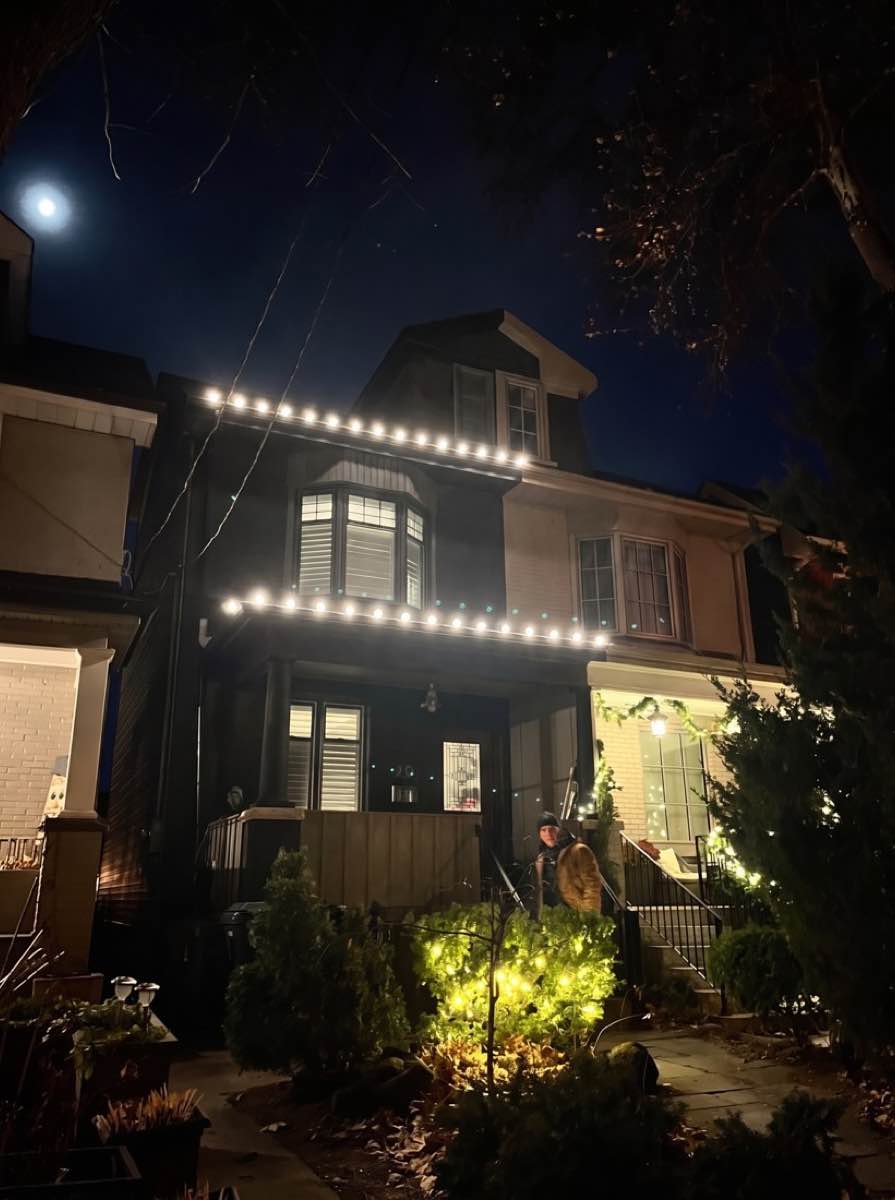 The same house with warm white lights along the front roofline