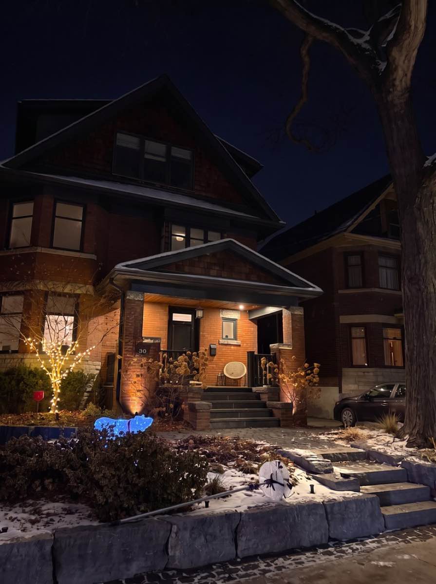 A house porch and front tree at night with no lights