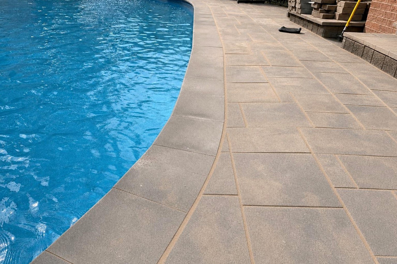 The same pool surround re-sanded with joints locked and pavers cleaned