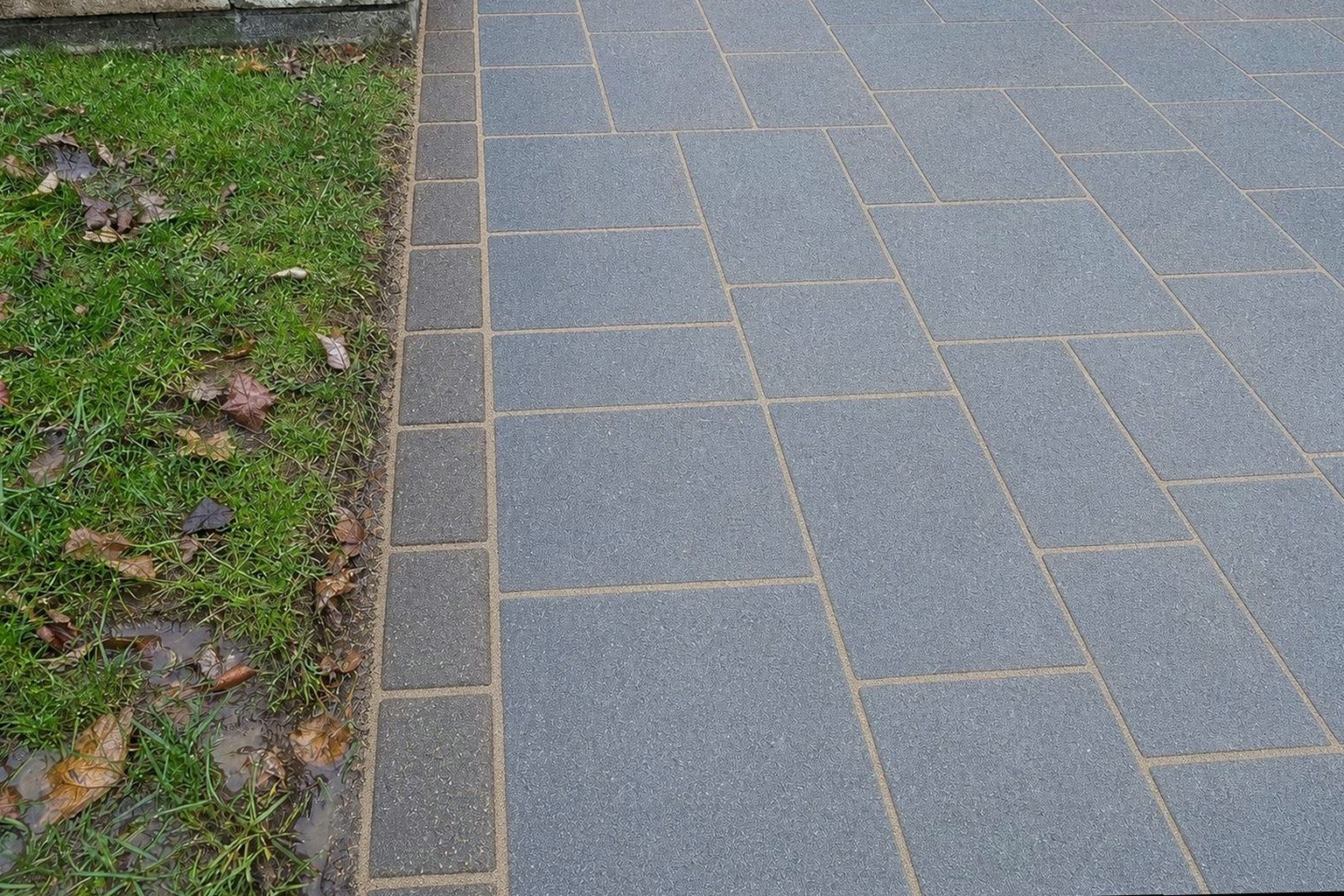 The same driveway edge cleaned and re-sanded so the edge course is locked in