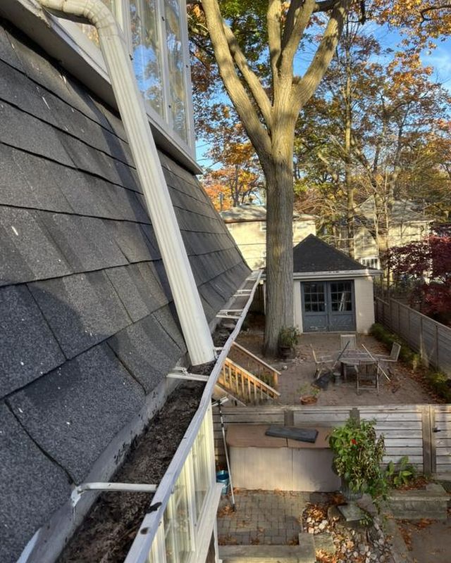The same gutter after clearing, clean with the downspout visible